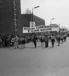 Poch&oacute;d Gwiaździsty, dzieci w strojach niosą transparent "Młodzież czerwonokrzyska w służbie narod&oacute;w". Ulica M. Curie-Skłodowskiej