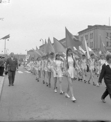 Poch&oacute;d Tysiąclecia, młodzież w strojach gimnastycznych niosąca flagi. Ulica M. Skłodowskiej-Curie.
