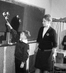 SP nr 5, uczeń przy tablicy, obok stoi nauczycielk pani Pisarska