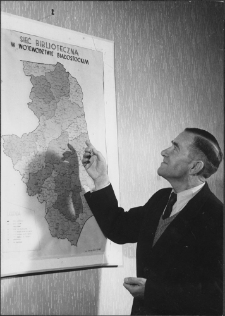 [Dyrektor Wojew&oacute;dzkiej i Miejskiej Biblioteki Publicznej w Białymstoku Władysław Malewski przy mapie przedstawiającej sieć biblioteczną w wojew&oacute;dztwie białostockim]