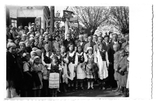 Zdjęcie grupowe, Henryk Sowiński w ciemnym płaszczu stoi pod znakiem, lata 20-30. XX w.