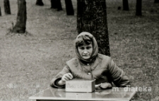 Kobieta sprzedająca losy, poch&oacute;d z okazji świięta 1 Maja, Aleja 1 Maja, Białystok, ok. 1978 r., fot. ze zbior&oacute;w Andrzeja Trzcińskiego