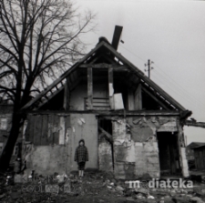 Portret dziewczynki na tle budynku z drewna, okolice ul. Młynowej, Białystok, druga połowa lat 70. XX w., fot. ze zbior&oacute;w Andrzeja Trzcińskiego