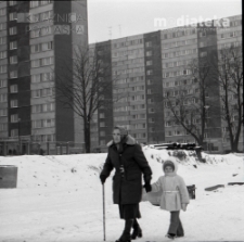 Starsza kobieta z dzieckiem na tle wieżowców, okolice ul. Młynowej, Białystok, druga połowa lat 70. XX w., fot. ze zbiorów Andrzeja Trzcińskiego