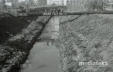 Dzieci siedzące na rurze ciepłowniczej nad rzeką Białą, Skwer Tamary Sołoniewicz, Białystok, druga połowa lat 70. XX w., fot. ze zbiorów Andrzeja Trzcińskiego