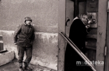 Portret kobiety w budce telefonicznej i mężczyzny podpierającego się o ścianę budynku, Białystok, druga połowa lat 70. XX w., fot. ze zbiorów Andrzeja Trzcińskiego