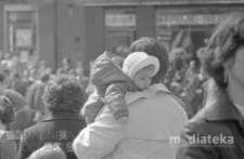 Pochód z okazji świięta 1 Maja, portret dziecka trzymanego na rękach, Aleja 1 Maja (obecnie Józefa Piłsudskiego), Białystok, druga połowa lat 70. XX w., fot. ze zbiorów Andrzej Trzcińskiego