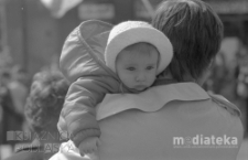 Pochód z okazji świięta 1 Maja, portret dziecka trzymanego na rękach, Aleja 1 Maja (obecnie Józefa Piłsudskiego), Białystok, druga połowa lat 70. XX w., fot. ze zbiorów Andrzej Trzcińskiego