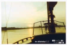 Łódka płynie w stronę zachodzącego słońca