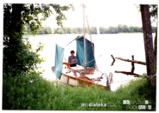 Kobieta na jachcie Okaz A-111, typ Karaś 450 na brzegu jeziora, 1987-2006 r.