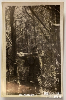 Mężczyzna z siekierą wśród drzew