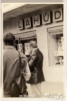 Dwóch mężczyzn przed witryną zagranicznego sklepu