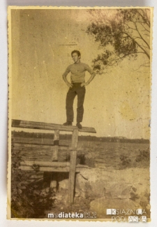 Mężczyzna stojący na balustradzie podestu, na tle jeziora, PGR Kociołek, 1973 r.