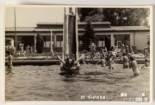 Chłopak wpadający ze zjeżdżalni do odkrytego basenu