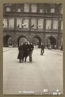 Uczniowie pozujący do zdjęcia na tle kamienicy podczas wycieczki