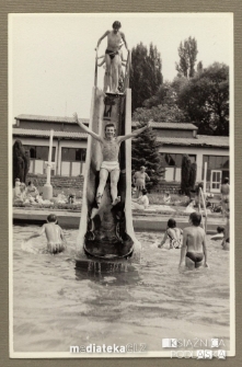 Chłopak wpadający ze zjeżdżalni do odkrytego basenu