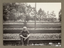 Chłopak siedzący na torach