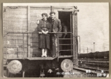 Para stojąca na podeście wagonu kolejowego