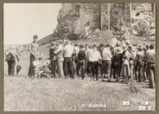 Grupa ludzi na wycieczce pod ruinami zamku