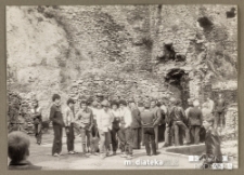 Grupa ludzi na wycieczce pod ruinami zamku