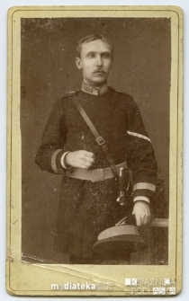 Portret mężczyzny w mundurze z czapką w lewej dłoni wykonany w atelier fotograficznym, 1890 r.