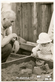 Dziadek bawi się z wnuczką w piaskownicy, Białystok - ul. Koszykowa 20, lata 60. XX w.