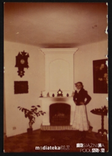 Portret Aliny Topolewicz przy kominku.