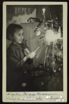 Ewa Jasińska trzyma zapalone zimne ognie podczas wigilii Bożego Narodzenia, Knyszyn, 24.12.1953