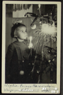 Iza Jasińska trzyma zapalone zimne ognie podczas wigilii Bożego Narodzenia, Knyszyn, 24.12.1953