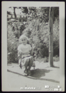 Dziewczynka na huśtawce w ogrodzie, lata 50. XX w.