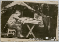 Para harcerzy siedząca przy stole przed namiotem, pocz. lat 70-tych XX w.