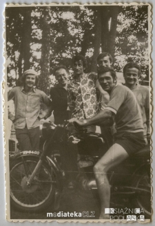 Młody chłopak pozujący na motocyklu marki WSK z kolegami