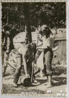 Harcerki pracujące na tle namiotu