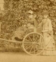 Dwie kobiety. Jedna w powozie, druga stoi oraz mężczyzna na tle domu