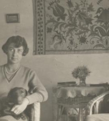 Kobieta i mężczyzna siedzących na fotelach przy okrągłym stole, pies na kolanach kobiety