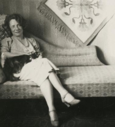 Maria Wieczorek siedzi na kanapie z kotem