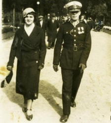 Młoda kobieta idąca z wojskowym alejką w parku