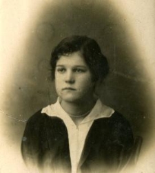 Portret kobiety ubranej w ciemny żakiet i białą bluzkę