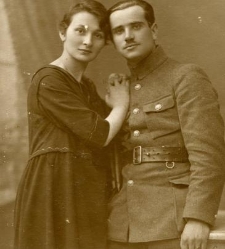 Kobieta w ciemnej sukni i mężczyzna w mundurze z pistoletem przy pasku