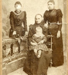 Trzy kobiety z małym dzieckiem na kolanach