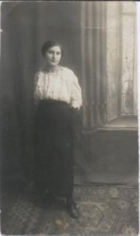 Kobieta w jasnej bluzce i długiej, ciemnej spódnicy