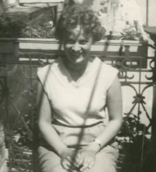 Młoda kobieta siedząca na balkonie kamienicy