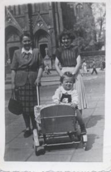 Dwie kobiety z dzieckiem w wózku, w tle kościół farny