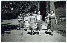 Grupa kobiet podczas przemarszu przez ulicę, z prawej strony zabudowania