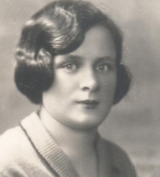 Portret kobiety z krótkimi ciemnymi włosami, ubranej w bluzkę z dzianiny